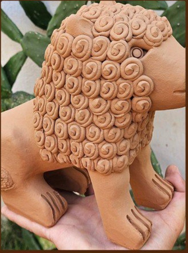 Leão cacheado segurado nas mãos do artesão